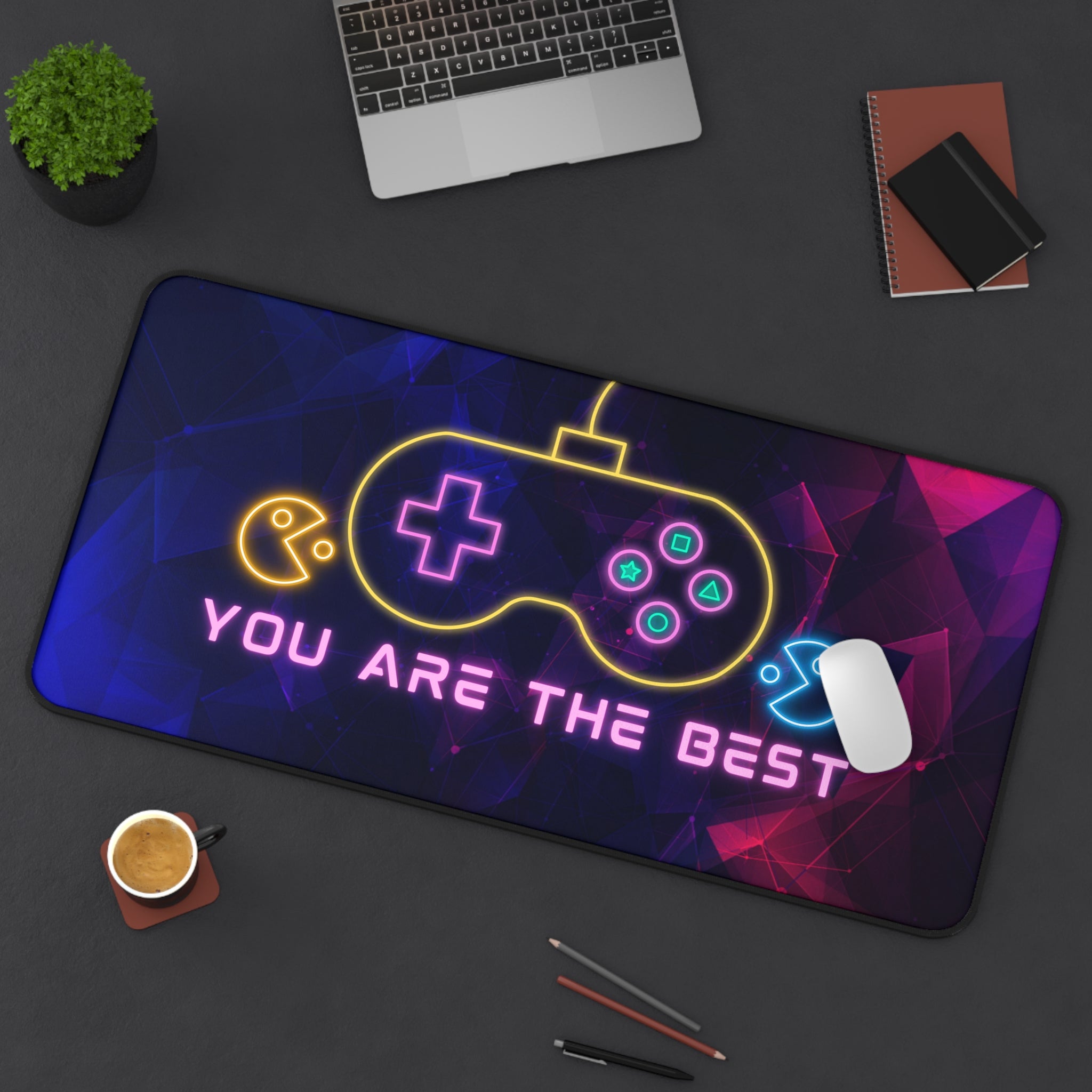 Gaming mouse pad with neon controller design and text on a desk setup.