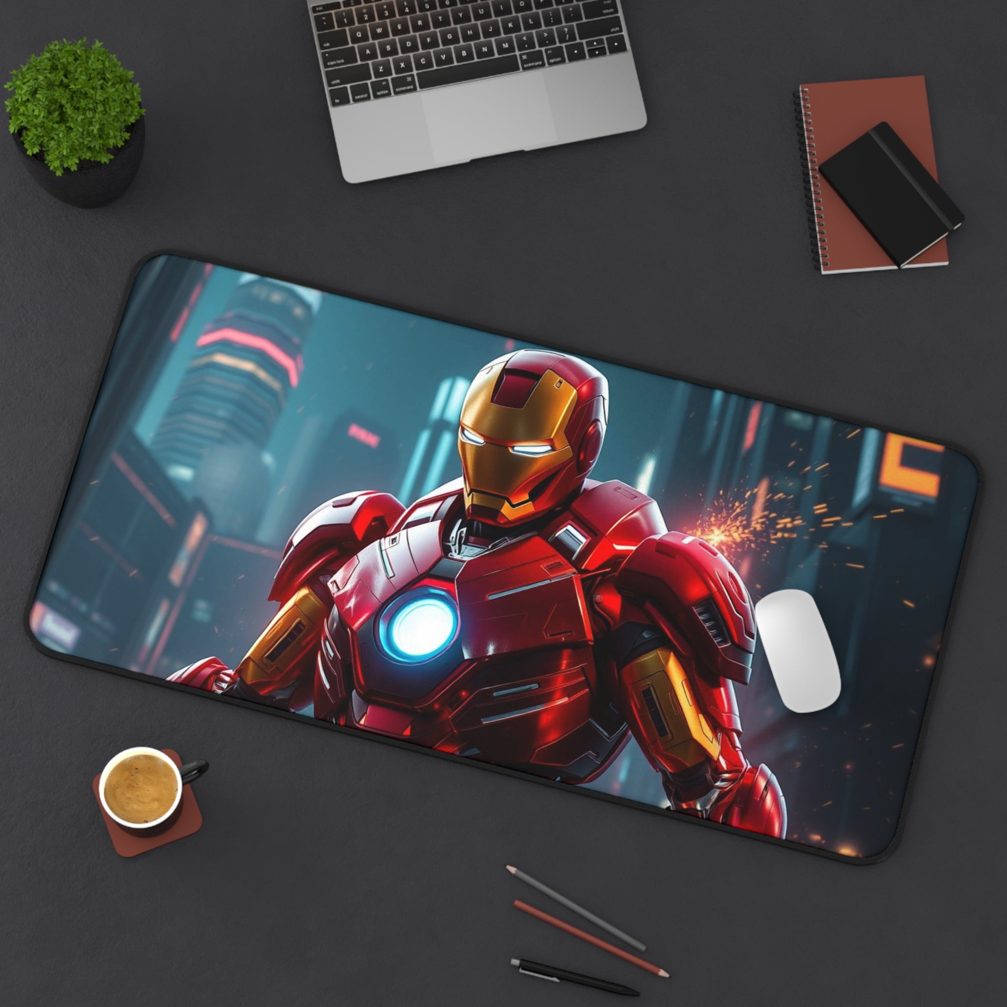 Desk setup with a large mouse pad featuring Iron Man, a laptop, coffee cup, and stationery items.