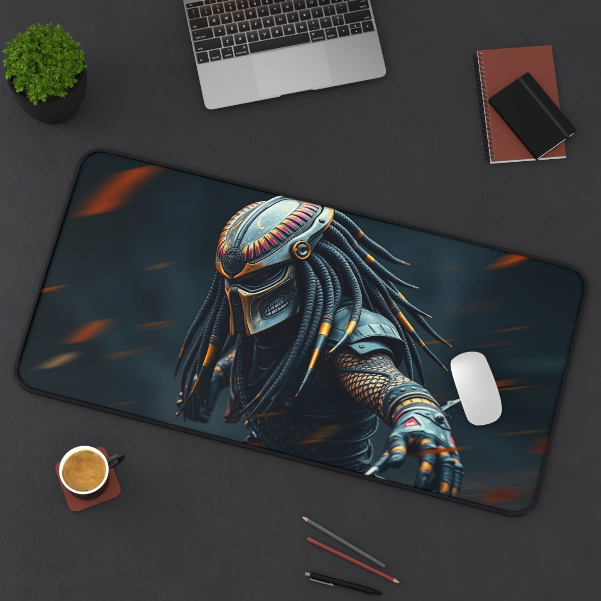 Mouse pad with a Predator design on a desk with a laptop, coffee, and pens.