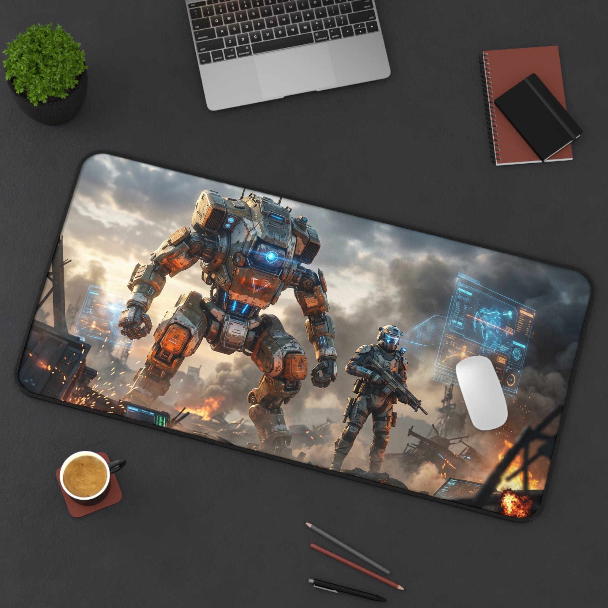 Desk setup with a large mouse pad featuring a robot and soldier design, laptop, notebook, and coffee cup.